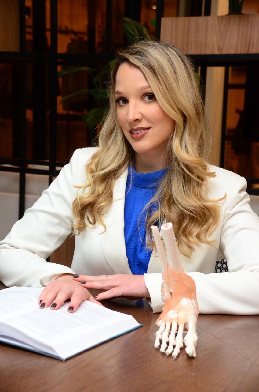 Dra. Elizabeth de Alvarenga Borges da Fonseca, ortopedista pediátrica, com modelo anatômico de pé
